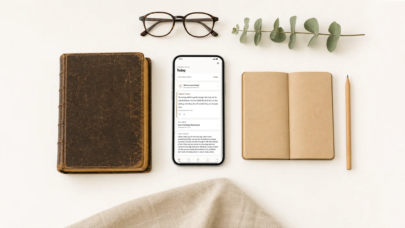 A Bible, notebook, and pencil laid out on a table with a phone showing the Today screen.